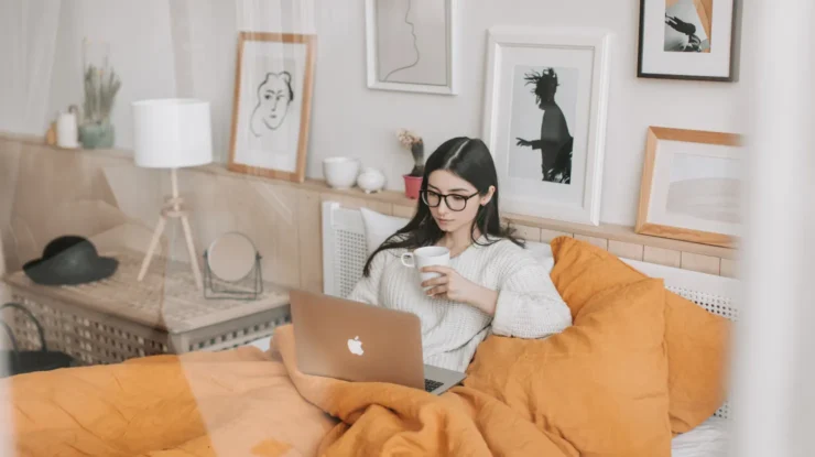 woman sits on couch shopping on the computer