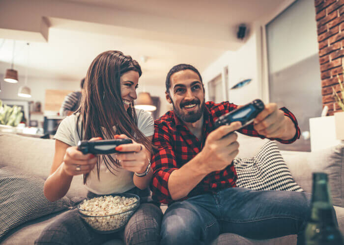 young couple on couch playing video games. 